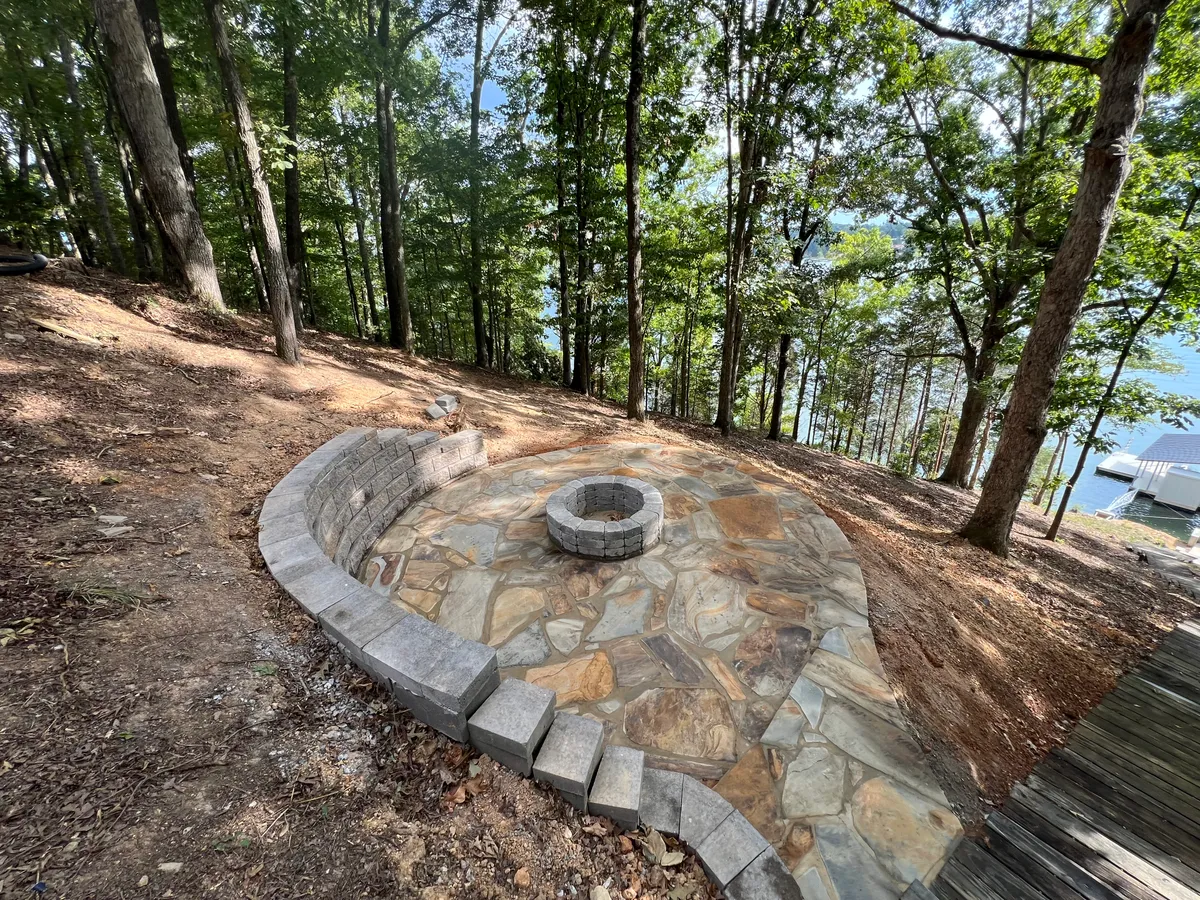 Flagstone fire pit seating area by lake